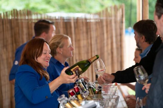 Vrouw schenkt wijn tijdens Bacchuis Wijnfestival