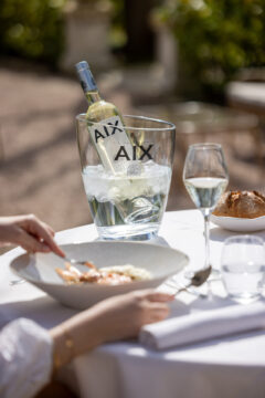 Fles AIX White 2024 in een koeler op eettafel