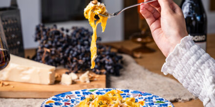 Hand met vork pasta