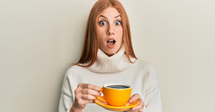 Vrouw met kopje koffie schrikt