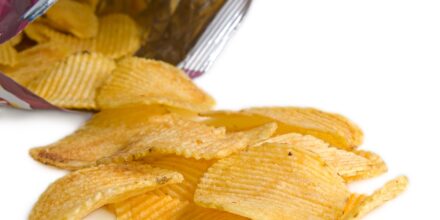 closeup of oval grooved potato chips with pack over white
