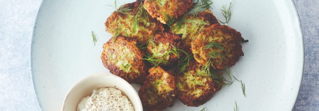 courgettebeignets op een wit bord met tzatziki