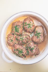 runderrollades met saus in een witte pan