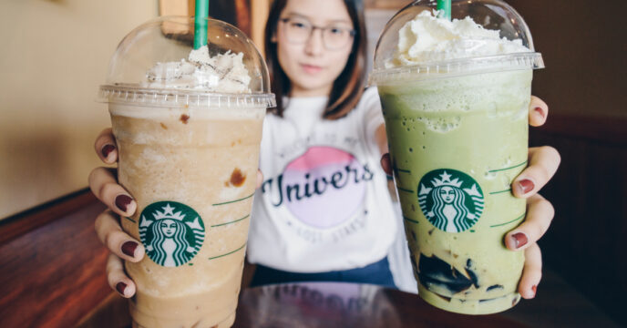 Vrouw houdt twee grote Starbucks ijskoffies vast