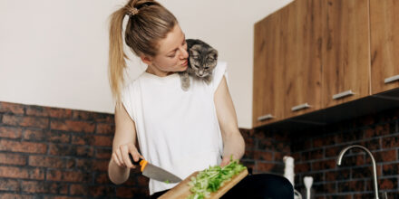 vrouw met poes snijdt groente