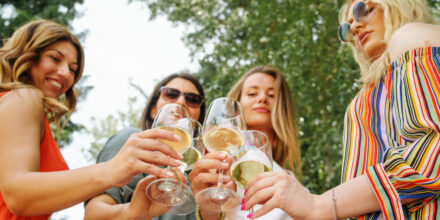 vrouwen proosten met witte wijn