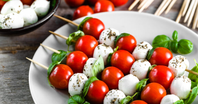 wit bord met caprese salade op stokjes